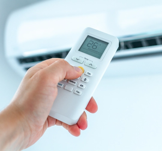 Someone holding a aircon remote.